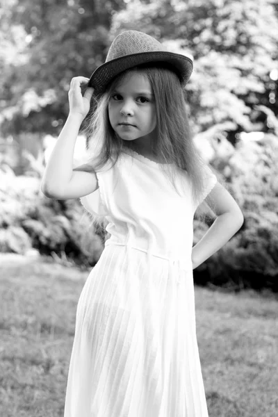 Retrato en blanco y negro de una niña con sombrero en estilo retro en un parque de verano al aire libre — Foto de Stock