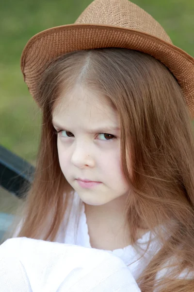 Vacker liten flicka i en vit klänning och hatt utomhus — Stockfoto