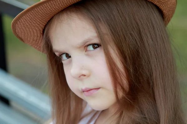 Glad liten tjej i en vacker hatt utomhus — Stockfoto