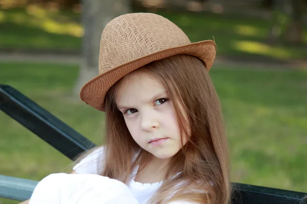 Urocza dziewczynka kapelusz pozowanie na kamery w parku lato na zewnątrz — Zdjęcie stockowe