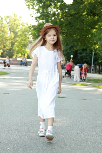 Glückliches kleines Mädchen mit einem schönen Hut im Freien — Stockfoto