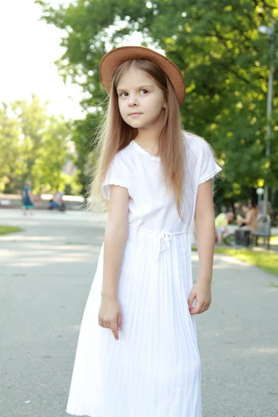 Happy little girl in a beautiful hat outdoors — Stock Photo, Image