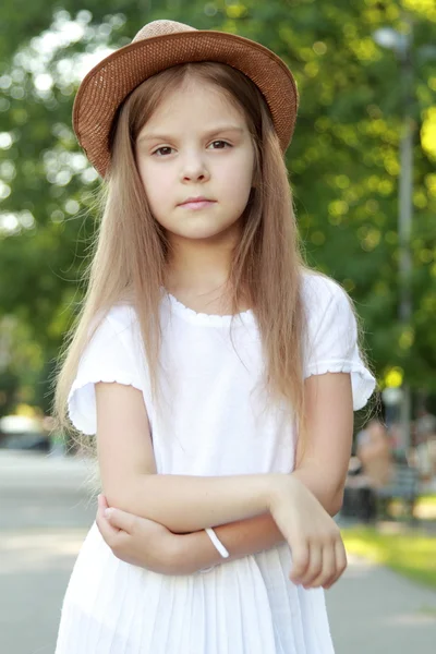 Happy little girl in a beautiful hat outdoors — Stock Photo, Image