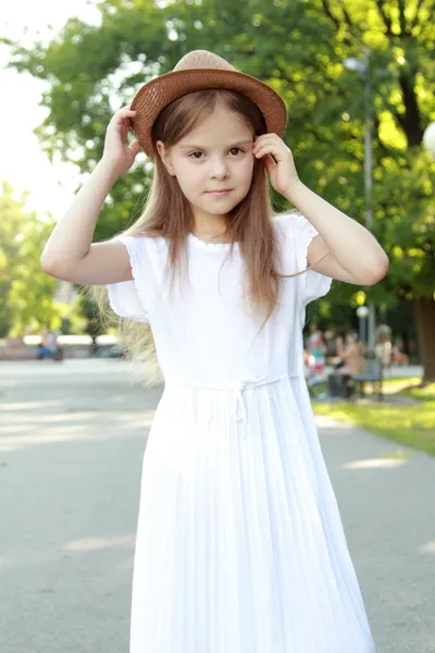 摆在相机中夏公园户外帽子的可爱小女孩 — 图库照片