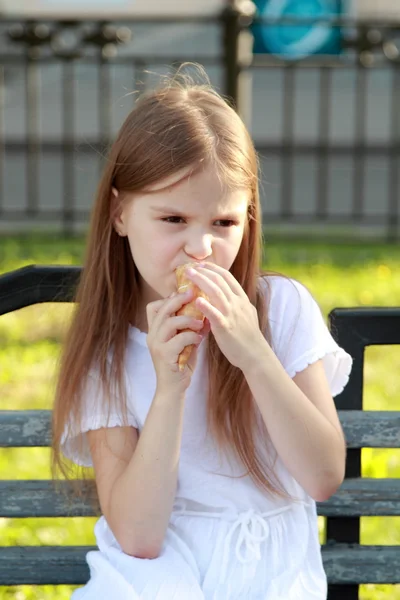 Niña en un vestido blanco es helado blanco al aire libre —  Fotos de Stock