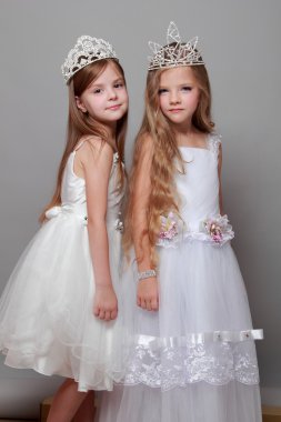 beyaz elbiseler içinde sevimli küçük kız ve bir taç Güzellik Yarışması için gülümseyen
