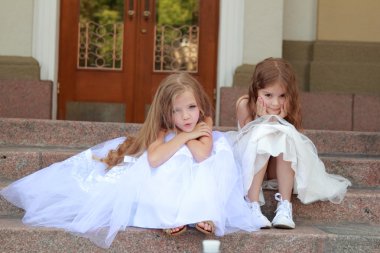 portre sevimli gülümseyen kız güzel bir elbise, uzun saçlı, açık havada basamaklarında oturan