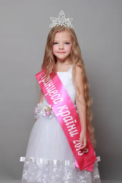 Hermosa chica en la corona fue la más hermosa en un concurso de belleza en Ucrania Adorable niña rubia en un hermoso vestido blanco y una corona ganó una princesitas tiernas —  Fotos de Stock