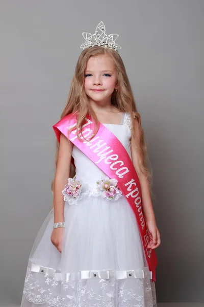 Niña en vestido de princesa con una cinta roja y la palabra "Princesa del país " — Foto de Stock