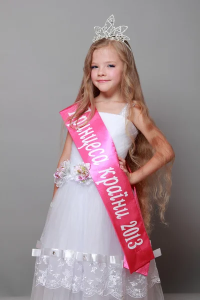 Klein meisje in prinses jurk met een rood lint en het woord "Prinses van het land" — Stockfoto