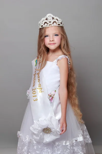 Charming young girl in a white ball gown sweet smiles — Stock Photo, Image