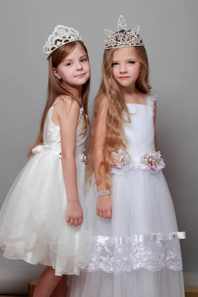 beyaz elbiseler içinde sevimli küçük kız ve bir taç Güzellik Yarışması için gülümseyen