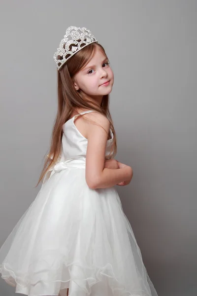 Europeu bonito menina vestindo uma coroa e um vestido branco com um sorriso bonito no feriado — Fotografia de Stock