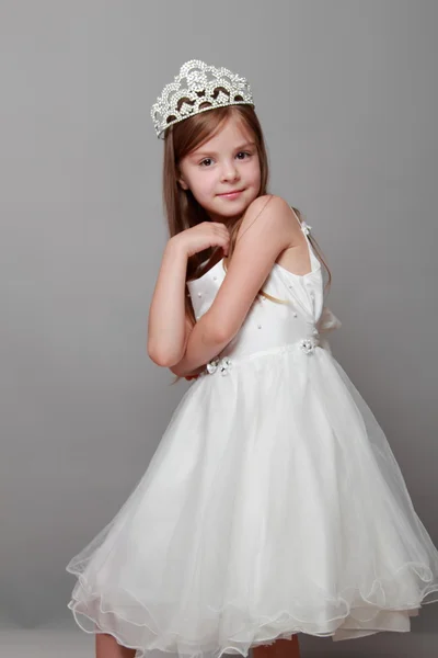 Europeu bonito menina vestindo uma coroa e um vestido branco com um sorriso bonito no feriado — Fotografia de Stock