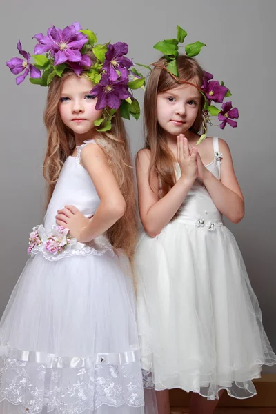 Dos hermosas niñas en vestidos blancos y peinados de clematis fresco —  Fotos de Stock