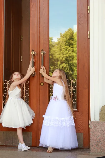 Маленькие девочки в белых платьях с длинными волосами на открытом воздухе — стоковое фото