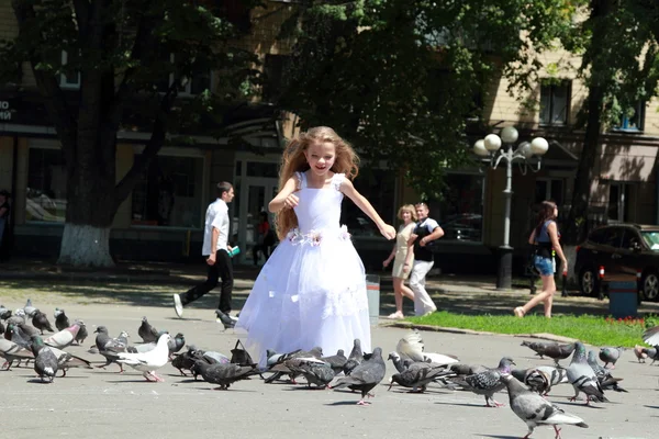 Glad glad tjej i vit brudtärna bröllopsklänningar mata duvor utomhus — Stockfoto
