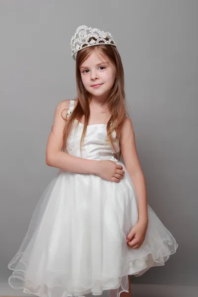 Europeu bonito menina vestindo uma coroa e um vestido branco com um sorriso bonito no feriado — Fotografia de Stock