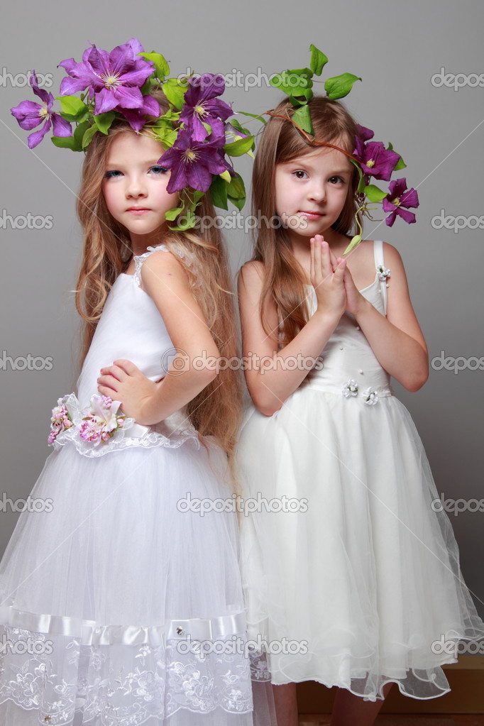 Two beautiful little girls in white dresses and hairdos from fresh