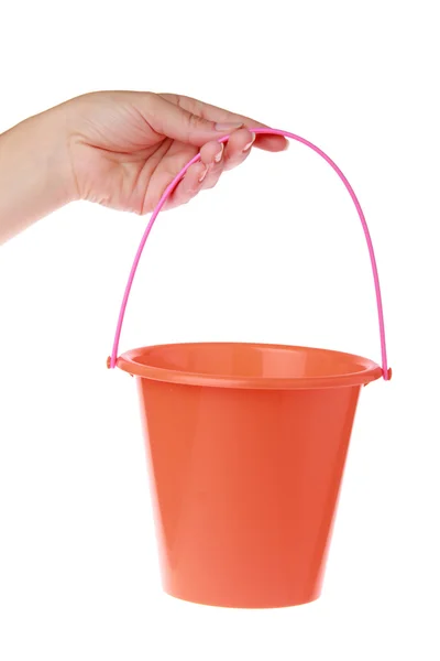 Female hand holding a baby red bucket on a white background — Stock Photo, Image