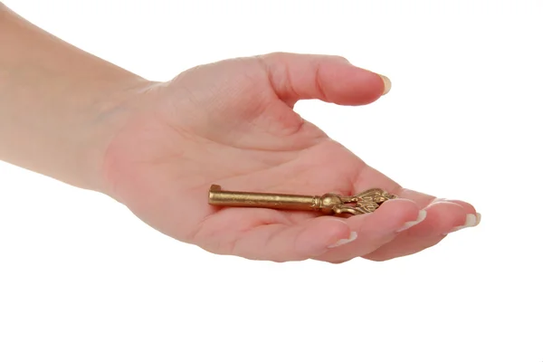 Vecchia chiave in metallo in una mano isolata su bianco — Foto Stock