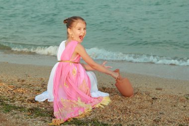 çok güzel bir elbise ile bir amfora Yunan tarzında, sevimli küçük kız gülümseyerek