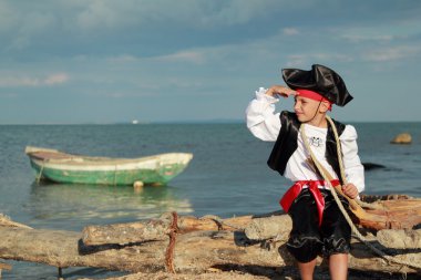 Handsome Boy dressed as a pirate on the sea coast
