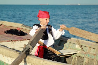 bir korsan gibi giyinen çocuk eski bir tekne denize yelken