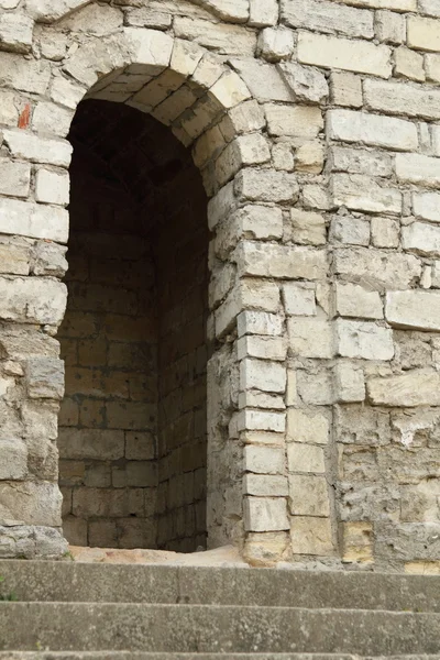 Старая кирпичная стена с арочным входом — стоковое фото