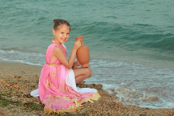 Lächelnd niedliches kleines Mädchen in einem schönen Kleid im griechischen Stil — Stockfoto