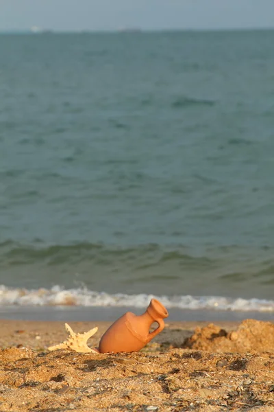 Amphore im Meerwasser, im Sommer von den Wellen am Strand angespült — Stockfoto