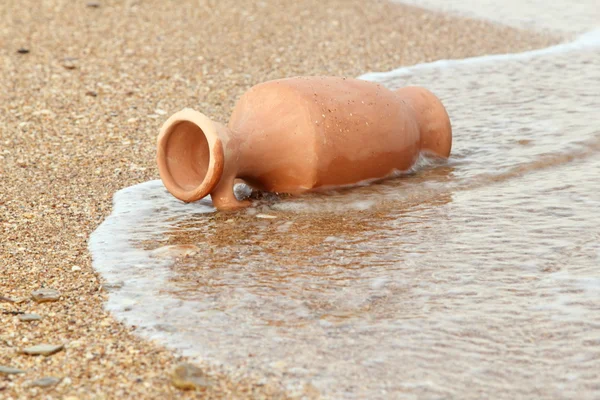 Hermosa ánfora vieja yaciendo en el agua en la playa —  Fotos de Stock