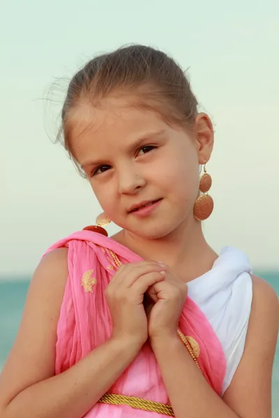 Portrait of a beautiful smiling little girl with beautiful hair and earrings — Stock Photo, Image