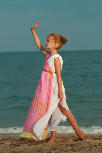 Sonriente niña linda en un hermoso vestido en estilo griego con un ánfora —  Fotos de Stock