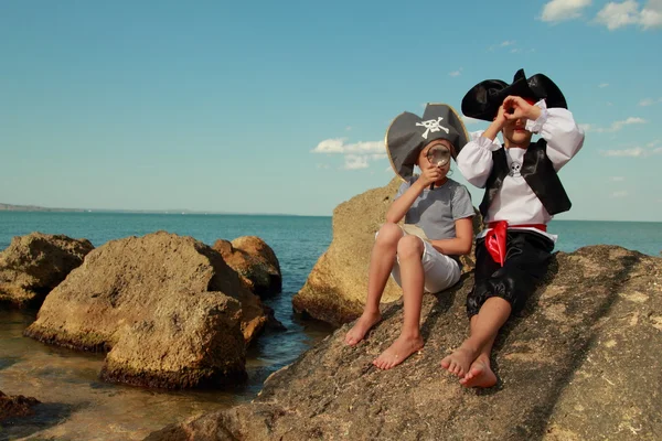 Menino e menina em um traje de pirata com um mapa e uma lupa — Fotografia de Stock