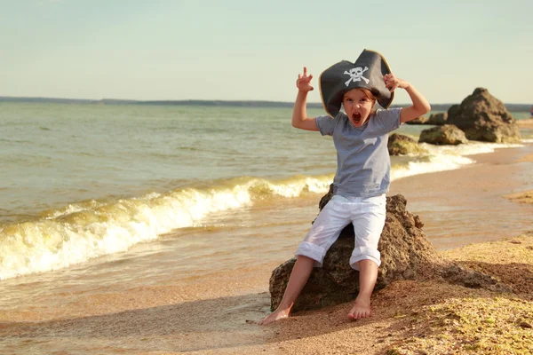 Böses kleines Piratenmädchen läuft an einem sonnigen Sommertag am Strand — Stockfoto