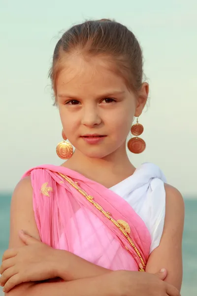 Portrait of a beautiful smiling little girl with beautiful hair and earrings — Stock Photo, Image