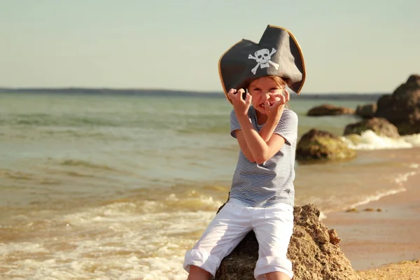 Onda little girl pirater kör på stranden i sommar solig dag — Stockfoto
