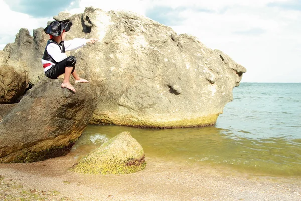 Arrabbiato ragazzino vestito da pirata è seduto su una grande roccia — Foto Stock