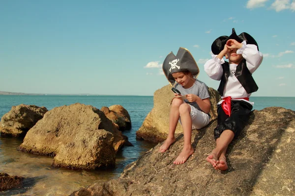 Bonitas crianças piratas menino e menina segurando um mapa pirata — Fotografia de Stock