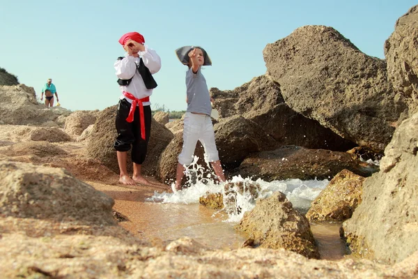 Lustige kleine Jungen und Mädchen im Piratenkostüm mit Landkarte und Lupe — Stockfoto