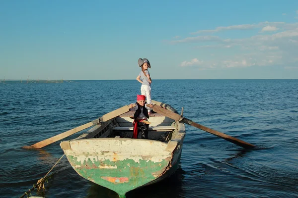 Mosolygós vidám fiú és lány játszik a kalóz öltözve ruhák és kalapok — Stock Fotó