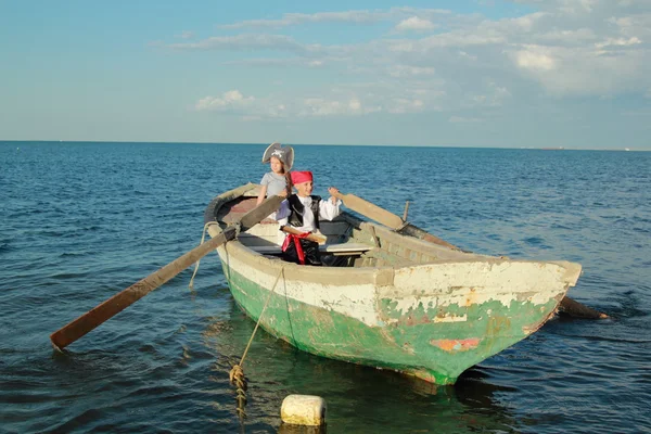 Lächelnder fröhlicher Junge und Mädchen beim Piratenspiel in Anzügen und Hüten — Stockfoto