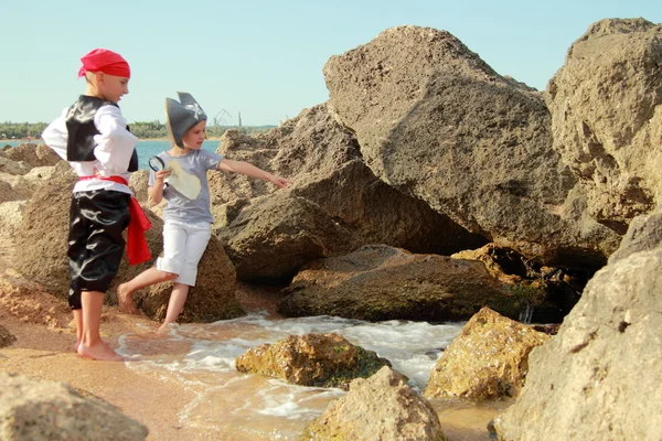 Funny little boy and girl in a pirate costume with a map and a magnifying glass — Stock Photo, Image