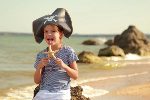 Caucasian sweet young girl in a pirate hat with a starfish — Stock Photo, Image