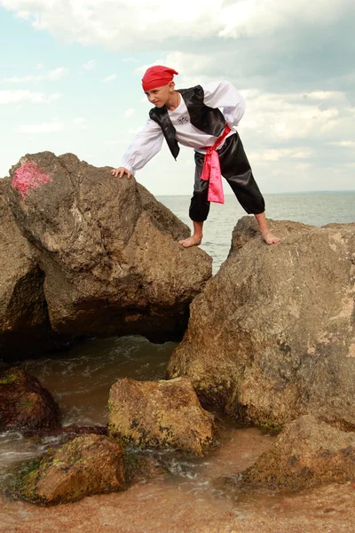 Retrato de um menino bonito vestido como um pirata em pé na praia — Fotografia de Stock