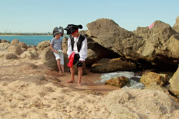 Engraçado menino e menina em um traje de pirata com um mapa e uma lupa — Fotografia de Stock