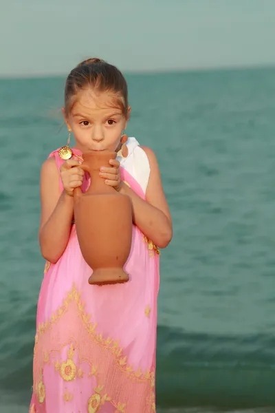 Sonriente niña linda en un hermoso vestido en estilo griego con un ánfora — Foto de Stock