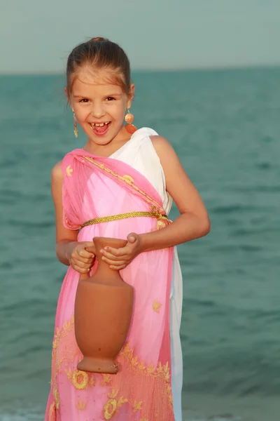 Lachende schattig klein meisje in een mooie jurk in Griekse stijl met een Amfora — Stockfoto