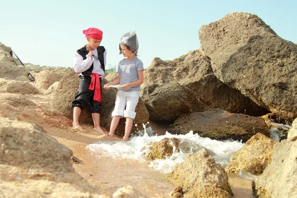 Niño y niña caucásicos pirata corsario pirata sosteniendo el mapa — Foto de Stock